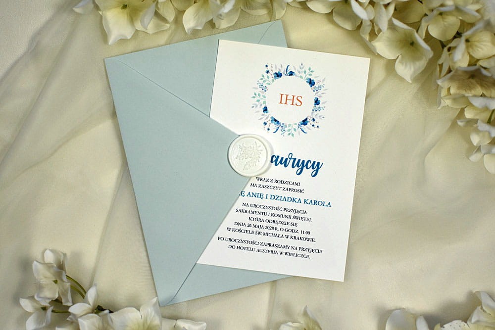 Nowoczesne zaproszenie na Chrzciny lub Komunię z niebieską kopertą i białą pieczęcią z laku.