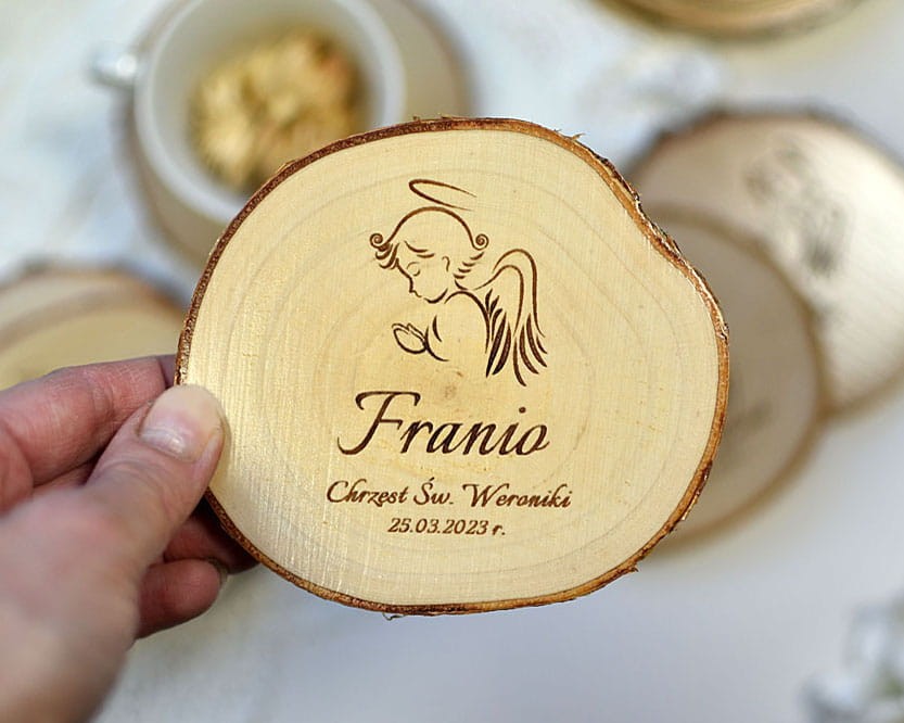 Drewniana podkładka pod kubek z wygrawerowanym aniołkiem.