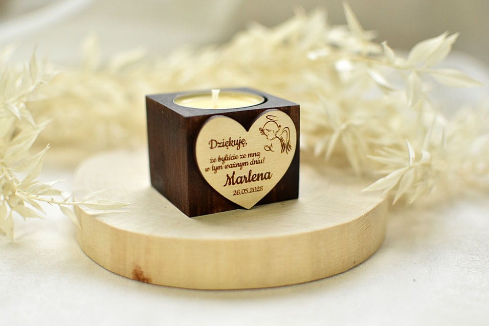Drewniany świecznik z napisem jako podziękowanie dla gości.