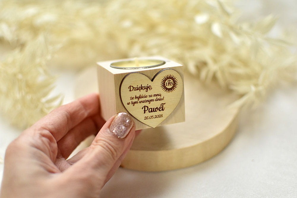 Pojedynczy świecznik z napisem jako prezent dla gości.